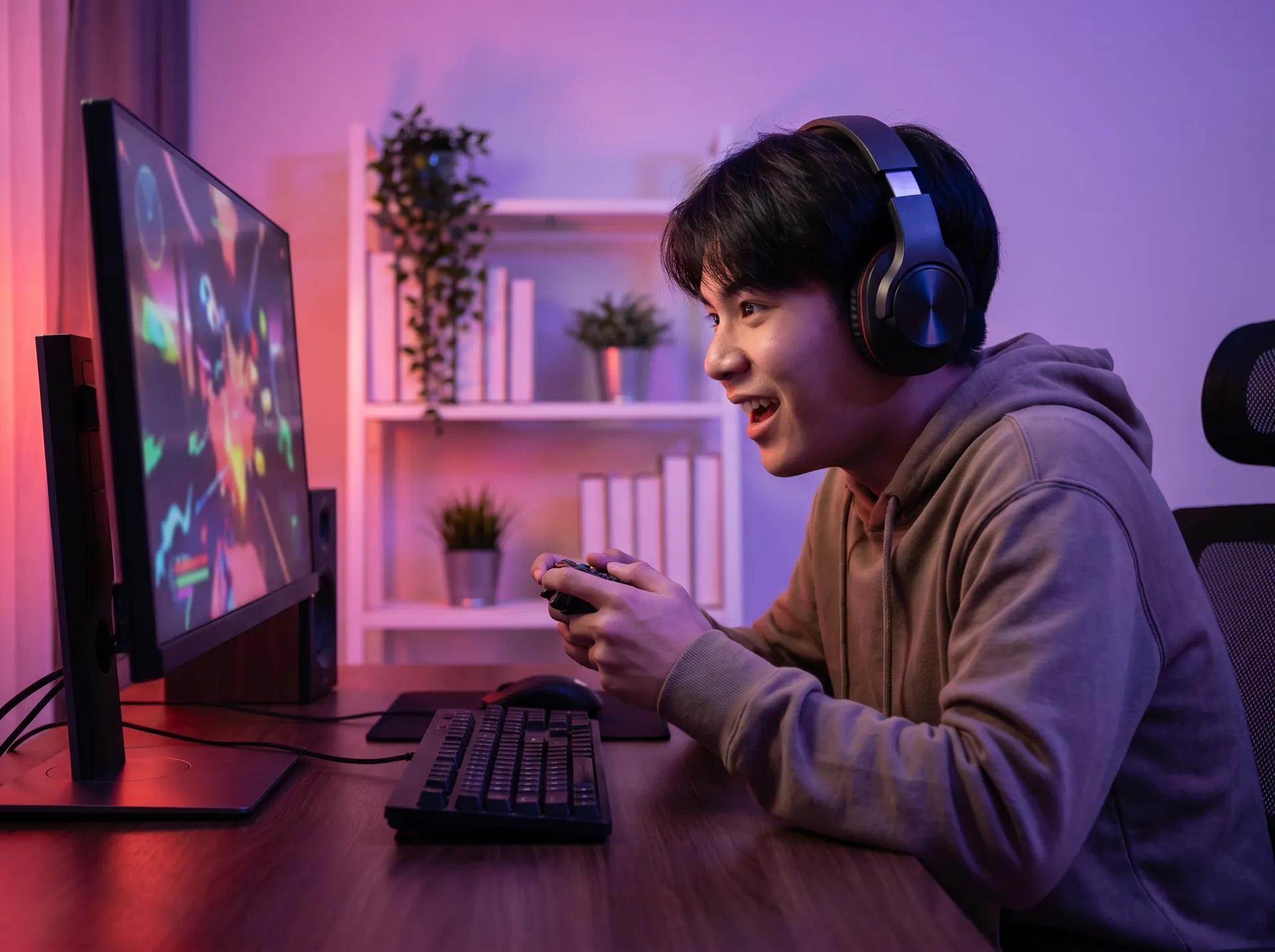 วัยรุ่นใส่หูฟังเล่นเกมคอมพิวเตอร์